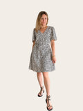 Vestido camisero de www.bambou.online con estampado de motas negras sobre fondo crudo, manga volante y cinturón.